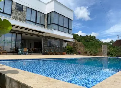 a swimming pool in front of a house at Finca Mirador de Santágueda in Palestina