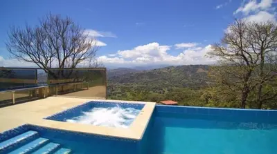 a blue swimming pool with a view of the mountains at Finca Mirador de Santágueda in Palestina