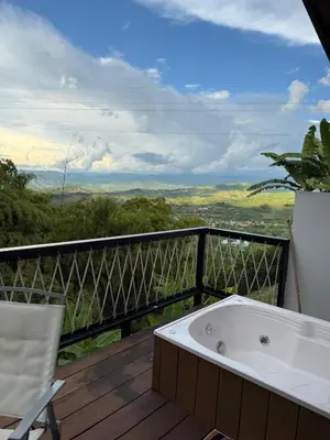 a bath tub sitting on a deck with a chair at Cabaña Hogar del Bosque in Palestina