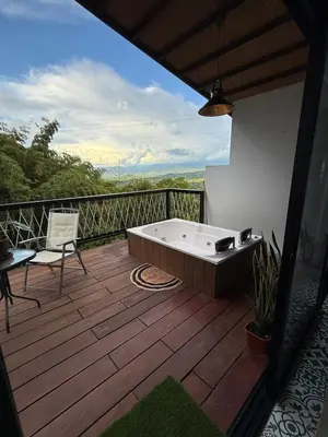 a bath tub sitting on a wooden deck with a balcony at Cabaña Hogar del Bosque in Palestina