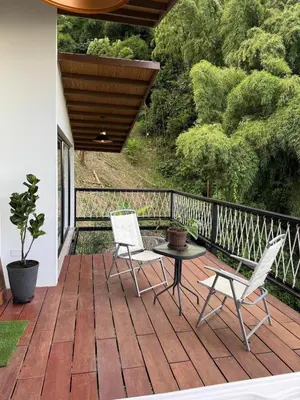 a patio with two chairs and a table on a deck at Cabaña Hogar del Bosque in Palestina