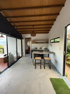 an outdoor kitchen with a table and stools at Cabaña Hogar del Bosque in Palestina