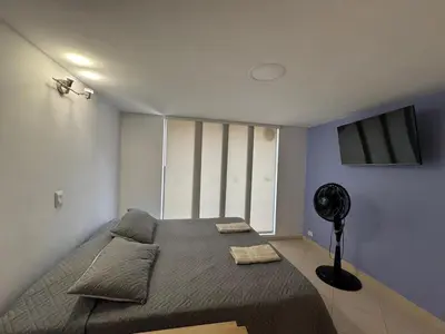 a bedroom with a large bed and a fan at Relaxing appartement in the middle of Poblado in Medellín