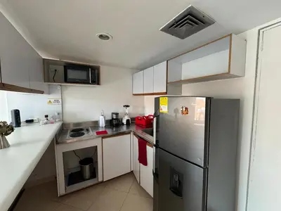 a small kitchen with a stainless steel refrigerator at Relaxing appartement in the middle of Poblado in Medellín