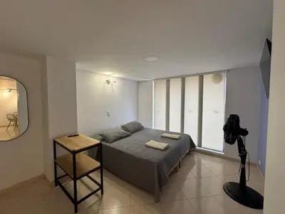 a bedroom with a bed and a large window at Relaxing appartement in the middle of Poblado in Medellín