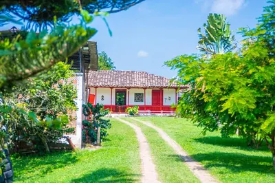 a house with red doors and a dirt road at Hacienda Santa Bárbara Coffee Farm in La Linda