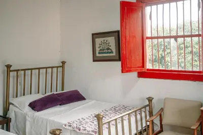 a bedroom with a bed and a red window at Hacienda Santa Bárbara Coffee Farm in La Linda