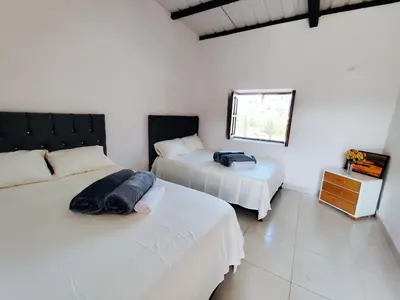 a bedroom with two beds and a window at Finca Tasnia in Chiquinquirá