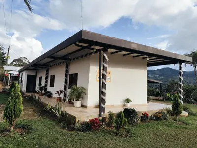 a small white building with a black roof at Finca Tasnia in Chiquinquirá