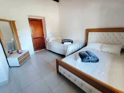 a bedroom with two beds and a dresser and a mirror at Finca Tasnia in Chiquinquirá