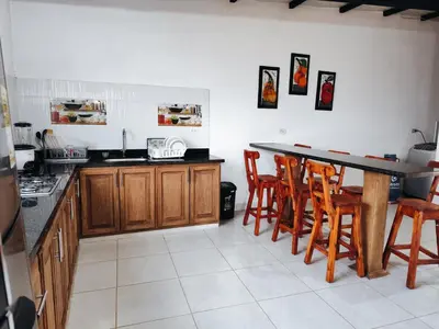 a kitchen with a table and some wooden chairs at Finca Tasnia in Chiquinquirá