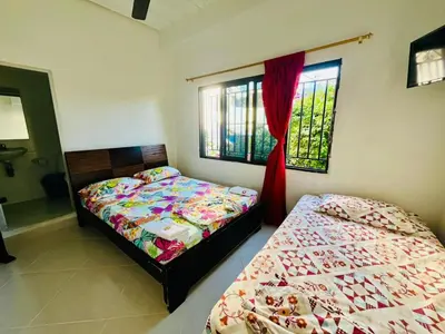 a bedroom with two beds and two windows at Cabaña 65 El Descanso Doradal in Estación El Salto