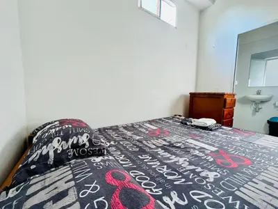 a bedroom with a bed with a black and white comforter at Cabaña 65 El Descanso Doradal in Estación El Salto