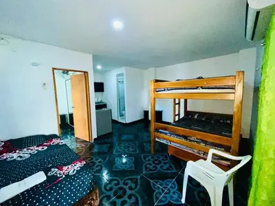 a bedroom with two bunk beds and a chair at Cabaña 65 El Descanso Doradal in Estación El Salto