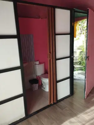 a bathroom with a toilet through a glass door at Marju Glamping in Manizales