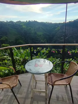 a table and chairs on a balcony with a view at Marju Glamping in Manizales