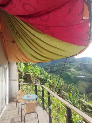 a room with a table and chairs on a balcony at Marju Glamping in Manizales