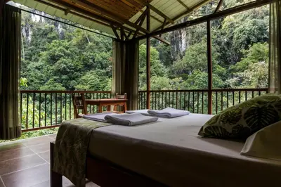 a bed in a room with a large window at Rio Claro Reserva Natural in San Francisco