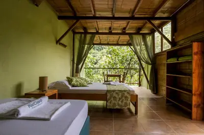 two beds in a room with a window at Rio Claro Reserva Natural in San Francisco