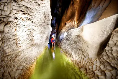 a person walking through a narrow slot canyon at Rio Claro Reserva Natural in San Francisco