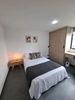a bedroom with a large bed and a wooden cabinet at Modern apartment in front of the Autonoma University - Manizales in Manizales