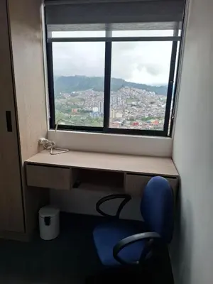 a window with a blue chair in front of a desk at Modern apartment in front of the Autonoma University - Manizales in Manizales