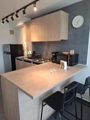 a kitchen with a counter with chairs and a counter top at Modern apartment in front of the Autonoma University - Manizales in Manizales