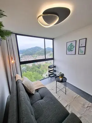 a living room with a couch and a large window at Modern apartment in front of the Autonoma University - Manizales in Manizales
