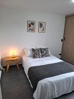 a bedroom with a bed and a table with a lamp at Modern apartment in front of the Autonoma University - Manizales in Manizales