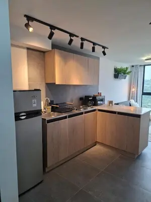a kitchen with wooden cabinets and a refrigerator at Modern apartment in front of the Autonoma University - Manizales in Manizales