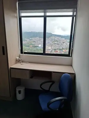 a window with a blue chair in front of a desk at Modern apartment in front of the Autonoma University - Manizales in Manizales