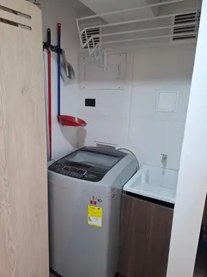 a small kitchen with a washing machine and a sink at Modern apartment in front of the Autonoma University - Manizales in Manizales