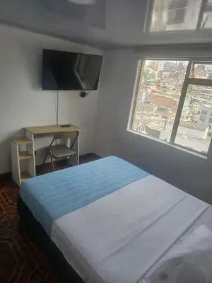 a bedroom with a bed and a desk and a window at Plaza de Toros & Centro Ubicación Ideal in Manizales