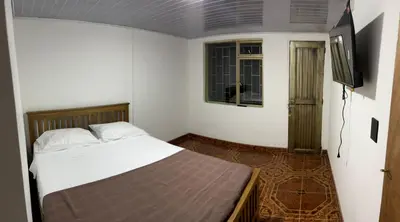 a bedroom with a bed and a flat screen tv at Plaza de Toros & Centro Ubicación Ideal in Manizales