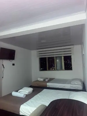 two beds in a room with a window at Plaza de Toros & Centro Ubicación Ideal in Manizales