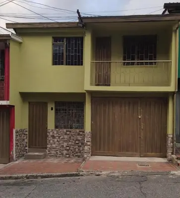 a yellow house with two garage doors at Plaza de Toros & Centro Ubicación Ideal in Manizales