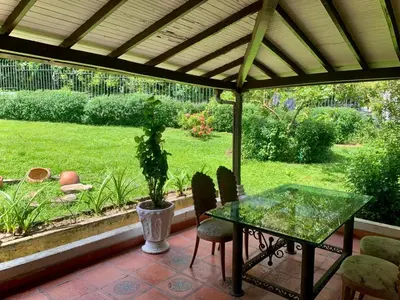 a patio with a glass table and chairs and a garden at Finca Hotel El Juncal in Venecia