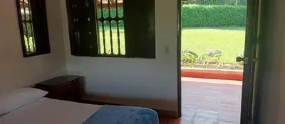 a bedroom with a bed and a view of a yard at Finca Hotel El Juncal in Venecia