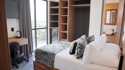 a bedroom with a bed and a large window at GIO Green Hotel Girardota Medellin in Girardota