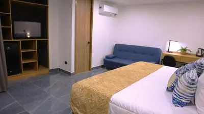 a hotel room with a bed and a blue couch at GIO Green Hotel Girardota Medellin in Girardota