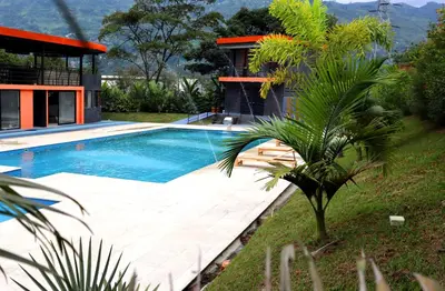 a swimming pool in front of a house at GIO Green Hotel Girardota Medellin in Girardota
