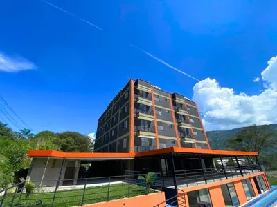 a tall building with a blue sky in the background at GIO Green Hotel Girardota Medellin in Girardota