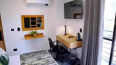 a room with a desk and a chair and a window at GIO Green Hotel Girardota Medellin in Girardota