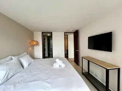 a bedroom with a white bed and a flat screen tv at PANORÁMIKA - Unique 1BD 1 and half Bath Best views Long term in Medellín