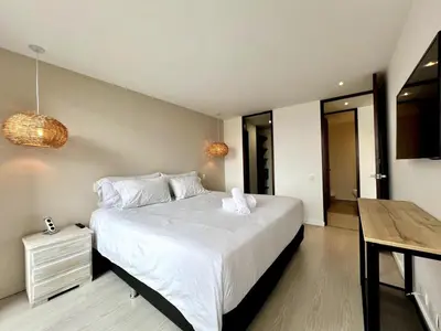 a bedroom with a large white bed and a table at PANORÁMIKA - Unique 1BD 1 and half Bath Best views Long term in Medellín