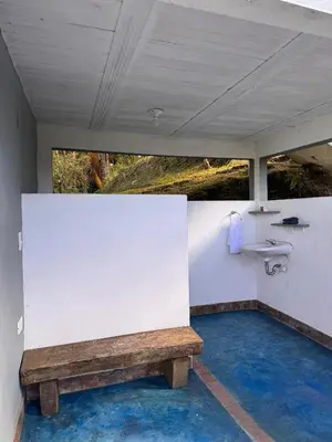 a bathroom with a sink and a wooden bench at Entre Nubes y Eucaliptos in Villamaría