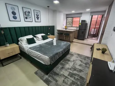 a bedroom with a bed and a kitchen with a sink at Acogedor aparta-loft con jacuzzi in Medellín