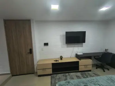 a room with a desk and a television on a wall at Acogedor aparta-loft con jacuzzi in Medellín