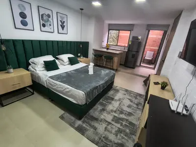 a bedroom with a bed with a green headboard at Acogedor aparta-loft con jacuzzi in Medellín