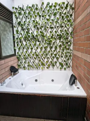 a white bath tub in a bathroom with a brick wall at Acogedor aparta-loft con jacuzzi in Medellín